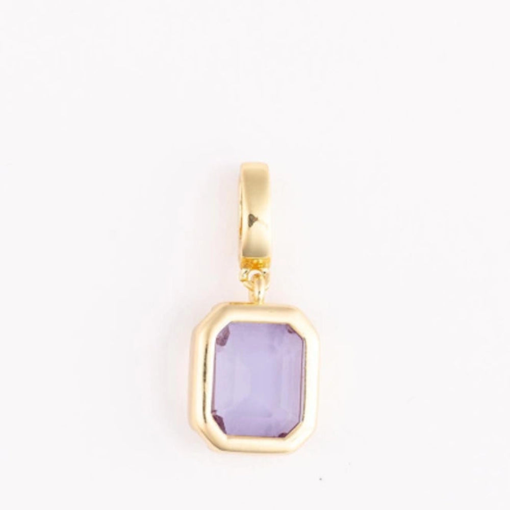 A polished gold pendant charm with an emerald-cut light purple gemstone on a plain white background.