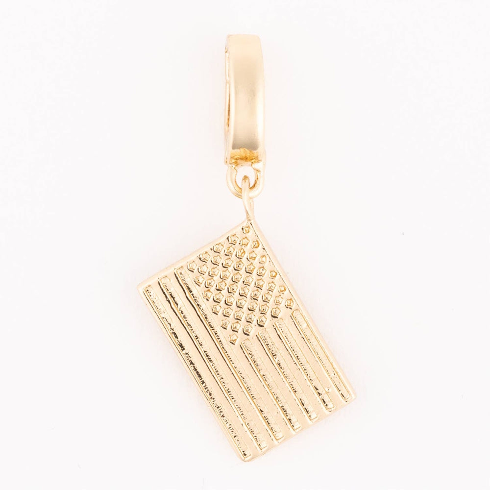 Gold American flag charm with embossed stars and stripes hanging from a smooth bail.
