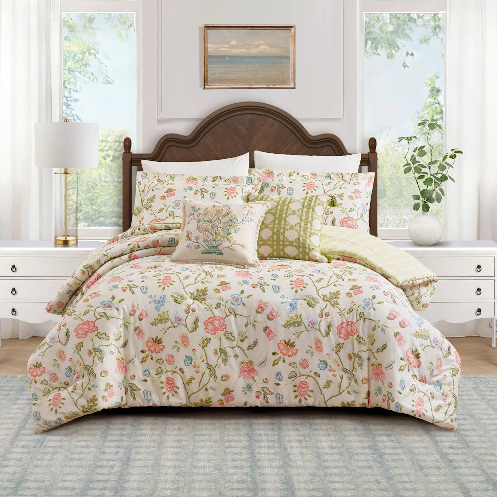 Floral comforter set with pink and green botanical patterns on a white bed in a bright, modern bedroom.