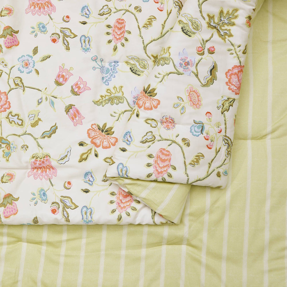 Floral botanical print comforter with reversible light green striped pattern for a cottagecore bedroom style.
