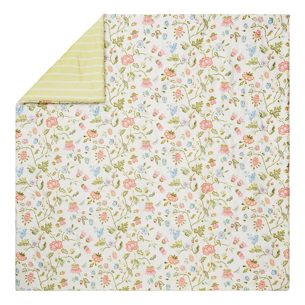 Reversible floral quilt featuring pink and peach blossoms with a yellow striped underside on a white base.