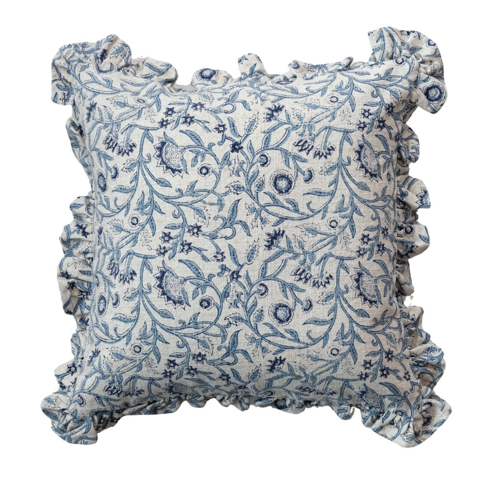 Square throw pillow with a blue and white block-printed floral pattern and a ruffled fabric border.