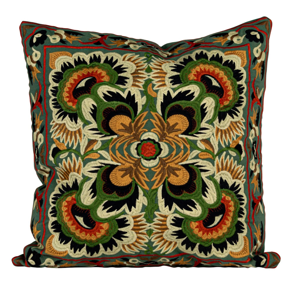 Embroidered floral throw pillow with green, orange, and black suzani-style pattern on a white background.