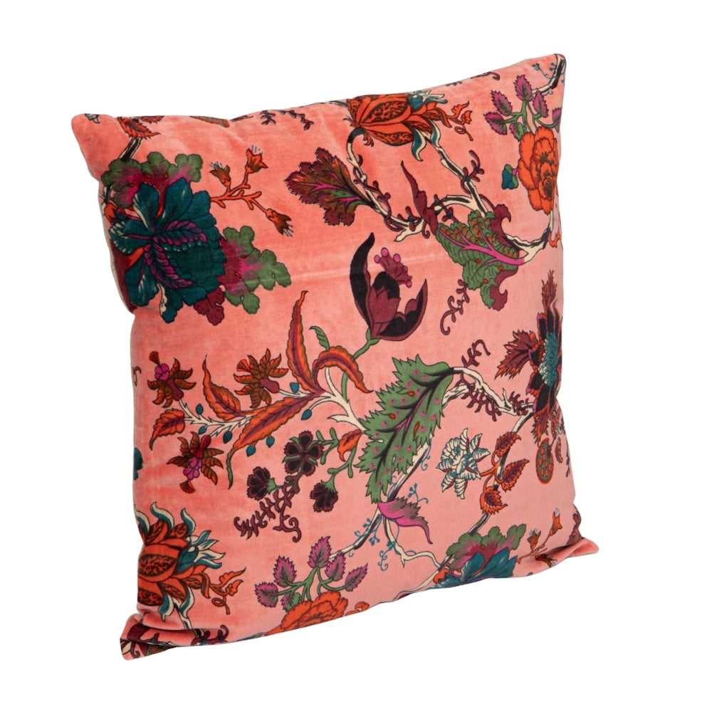 Pink velvet throw pillow with colorful vintage floral embroidery and botanical patterns on a white background.