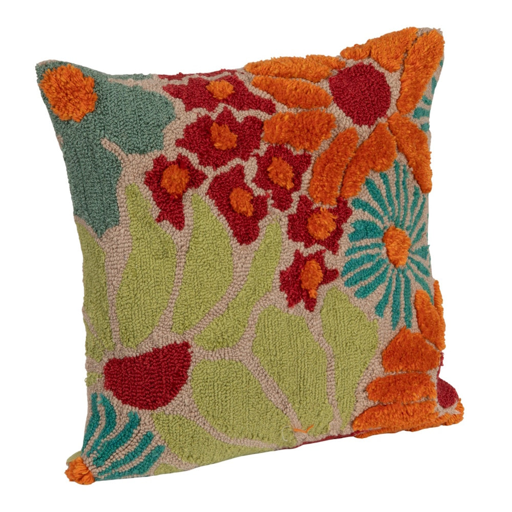 Side view of a square floral tufted pillow featuring orange, red, and teal hooked fabric flowers on a beige background.