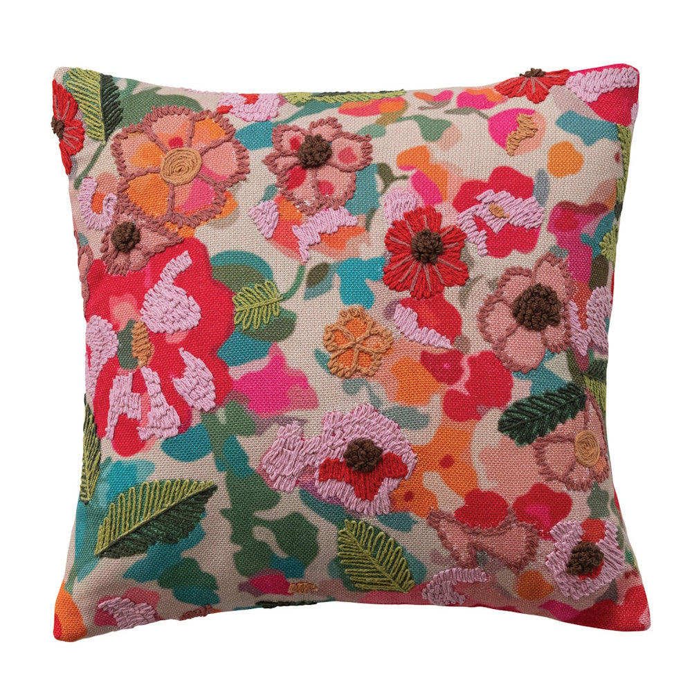 Square throw pillow with colorful embroidered floral patterns in pink, red, and orange on a beige background.