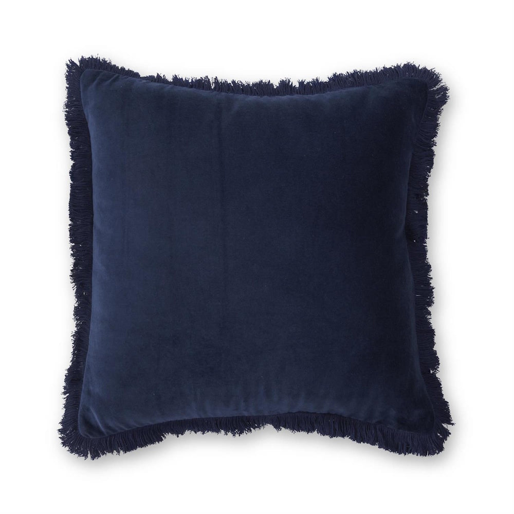 Navy blue velvet throw pillow with decorative fringe trim, isolated on a white background.