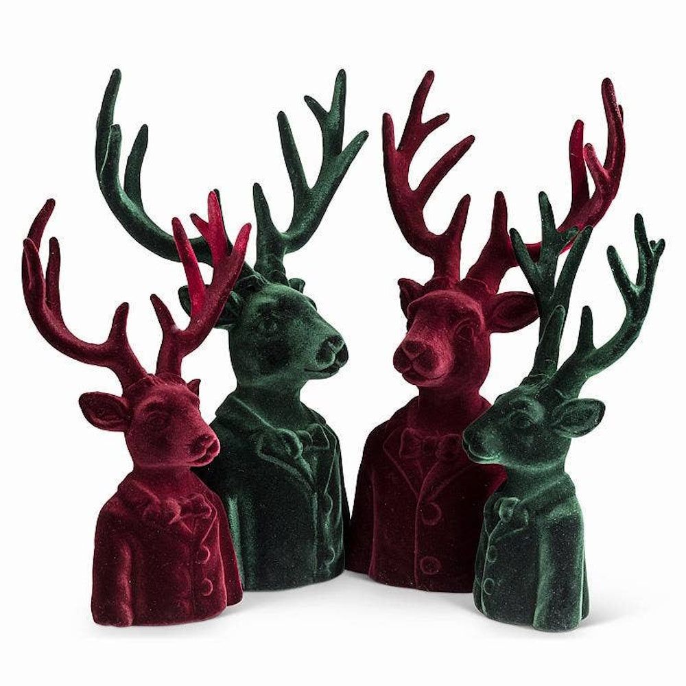 Four velvet stag bust figurines in red and green, styled in suit jackets with bow ties.