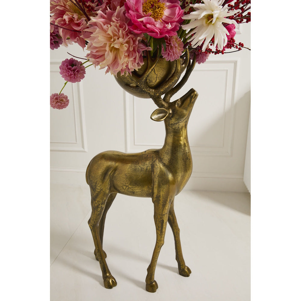 Close-up of the bronze deer bowl filled with pink and white floral arrangements.