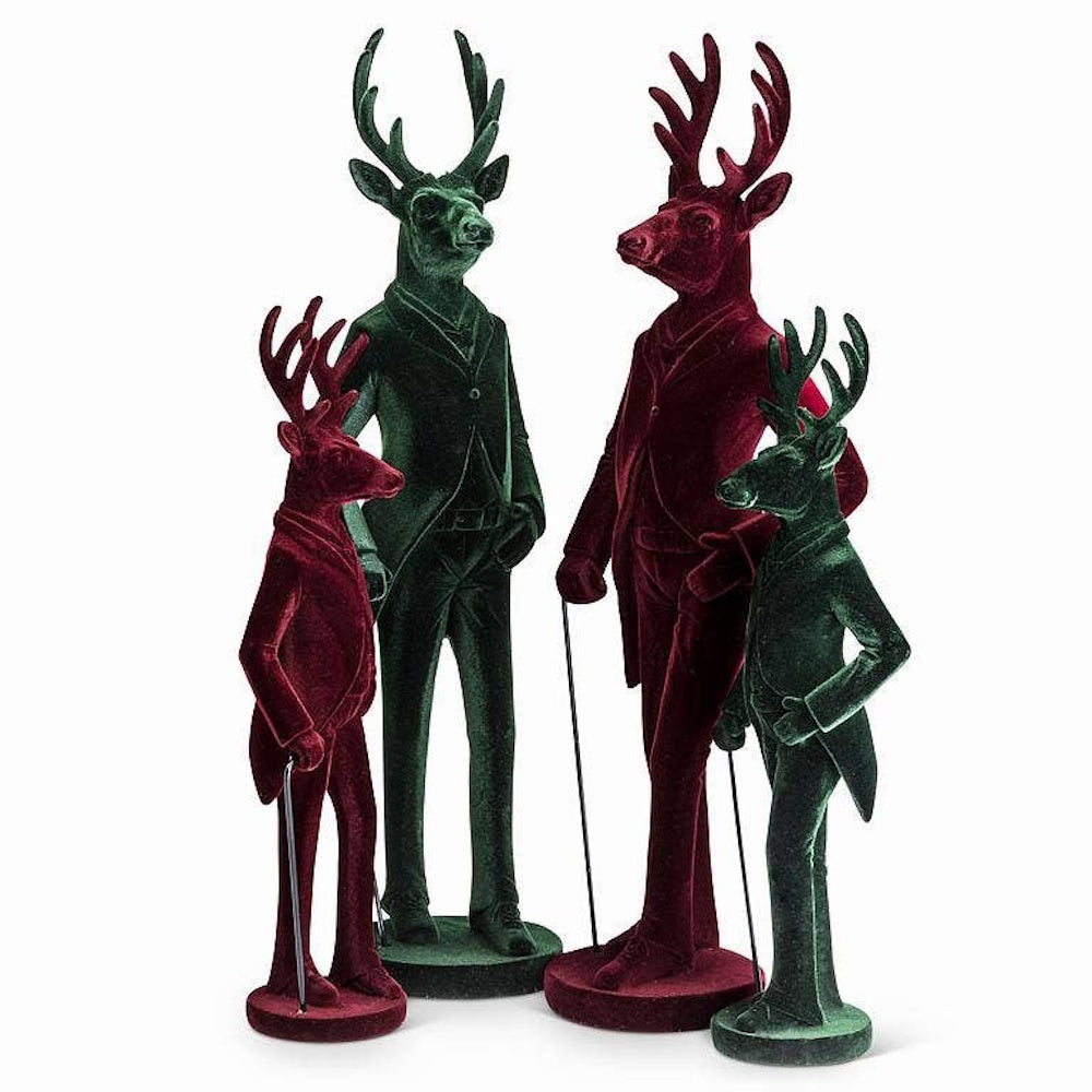Four velvet stag figurines in red and green suits, styled like dapper Victorian deer.