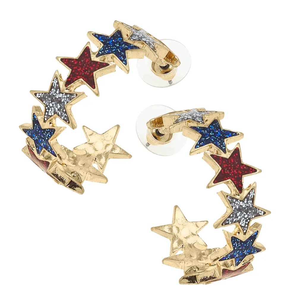 A pair of gold hoop earrings shaped like rows of stars filled with red, white, and blue glitter.