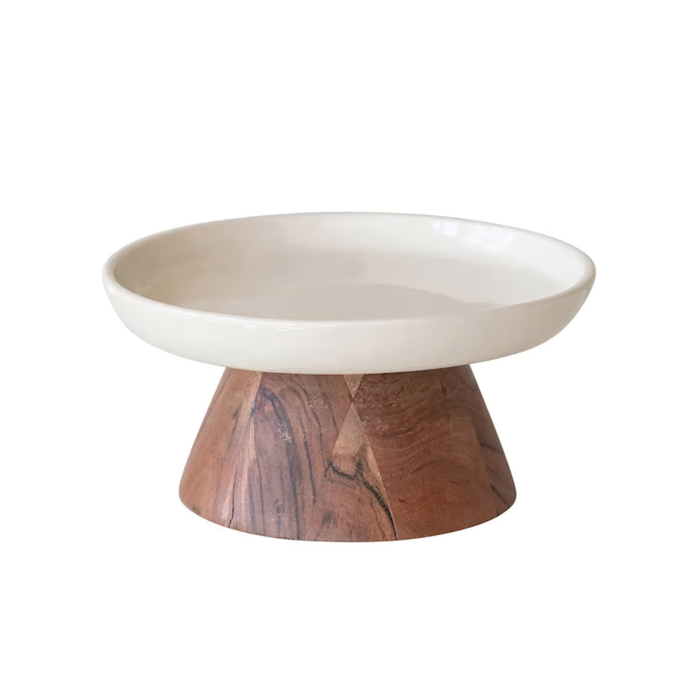 Off-white ceramic shallow dish elevated on a tapered natural wood pedestal base.