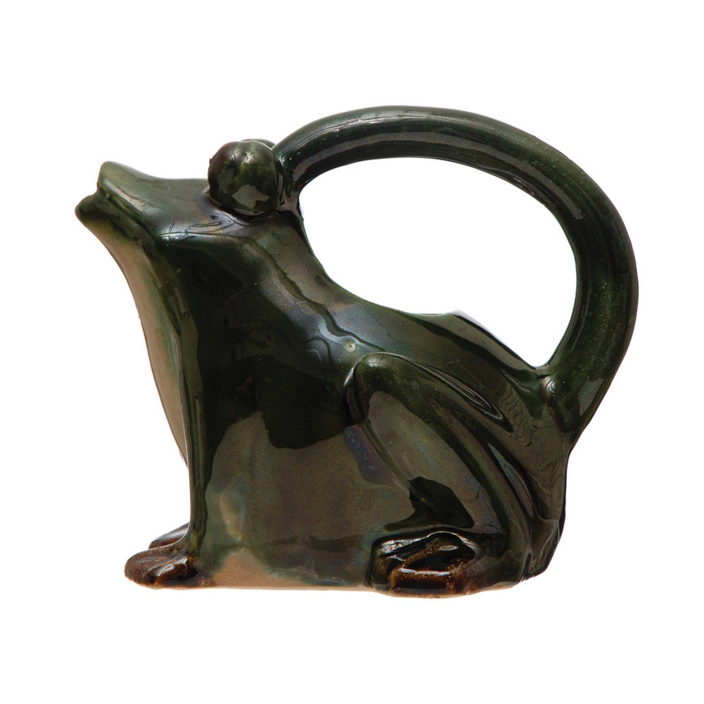 Side view of a glossy green ceramic frog pitcher, featuring a curved handle spanning from its back to its head.