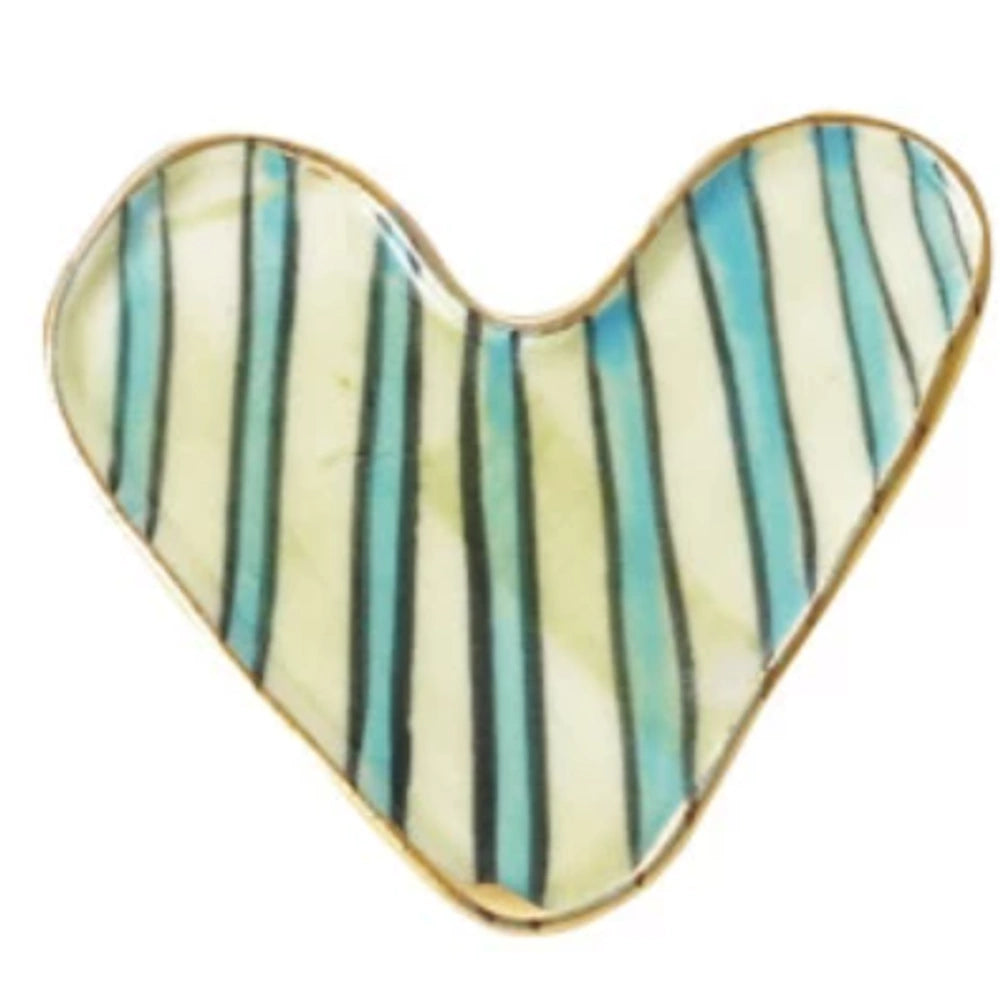 A simple porcelain heart-shaped dish with hand-painted blue, green, and black vertical stripes and a gold rim.