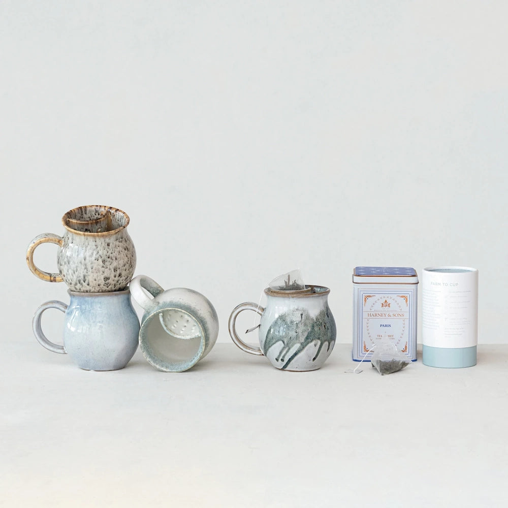 Handmade pottery tea mugs with infusers and Harney and Sons tea canister for loose leaf tea brewing.