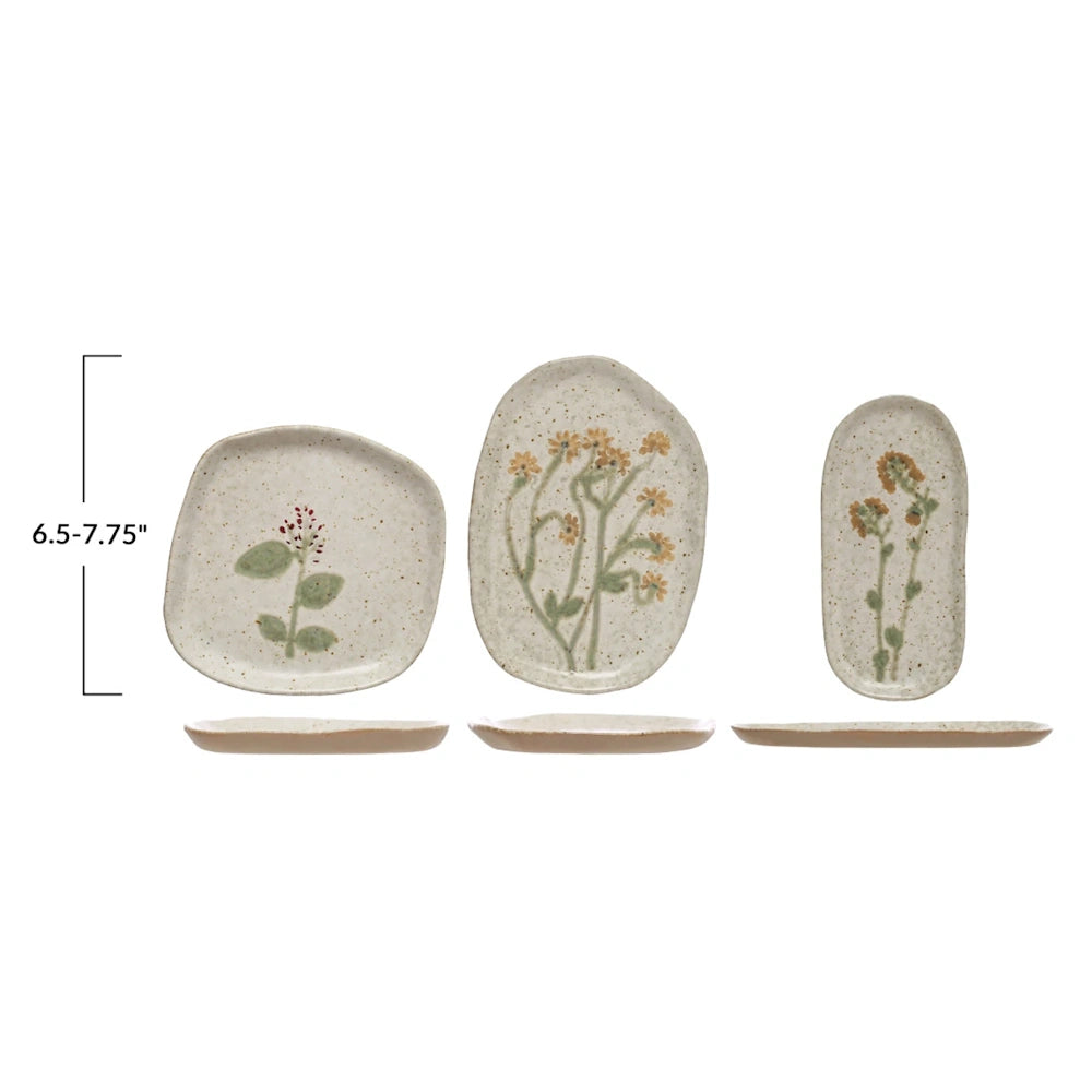 Three botanical-patterned ceramic plates shown with a height dimension bracket indicating 6.5 to 7.75 inches.