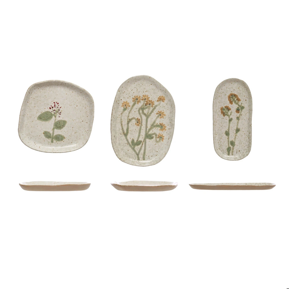 Set of three organic-shaped speckled ceramic plates with painted botanicals, shown top-down and in profile.