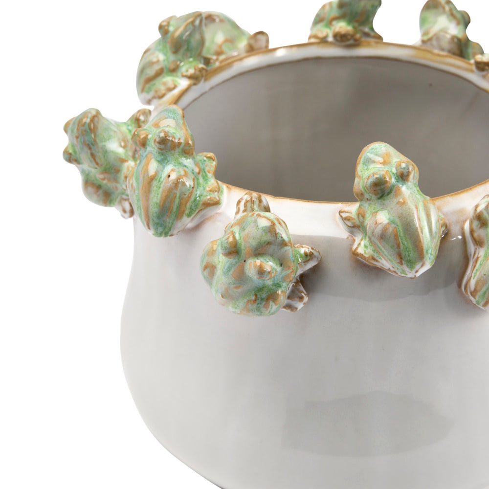 A white ceramic planter with small green and brown glazed frogs perched along the upper rim.
