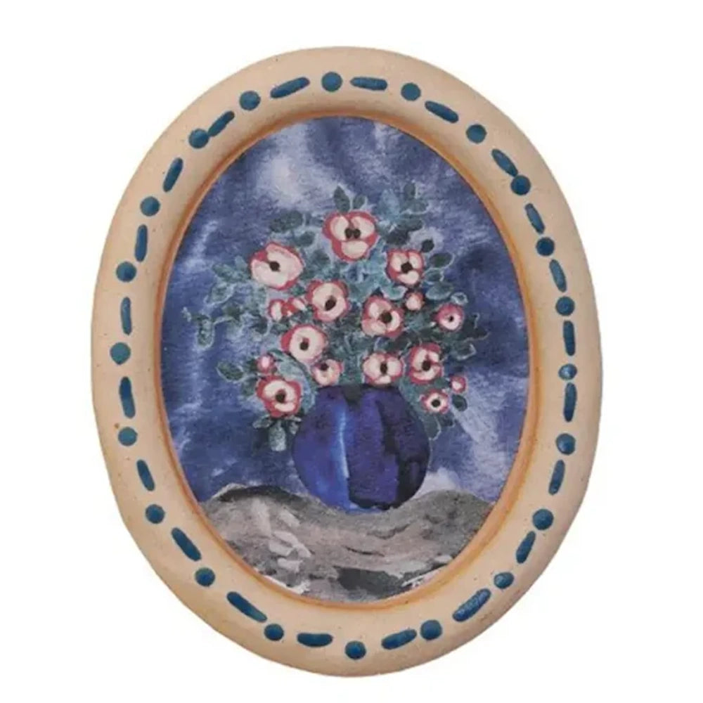 Oval floral still life watercolor art featuring pink blossoms in a round blue vase within a decorative ceramic frame.