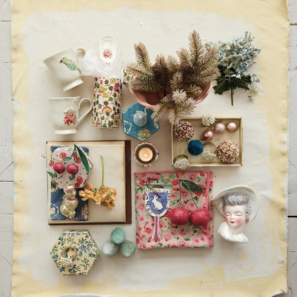 Flat lay view of a collection of home decor and gift items featuring a white ceramic lady head vase on a neutral surface.