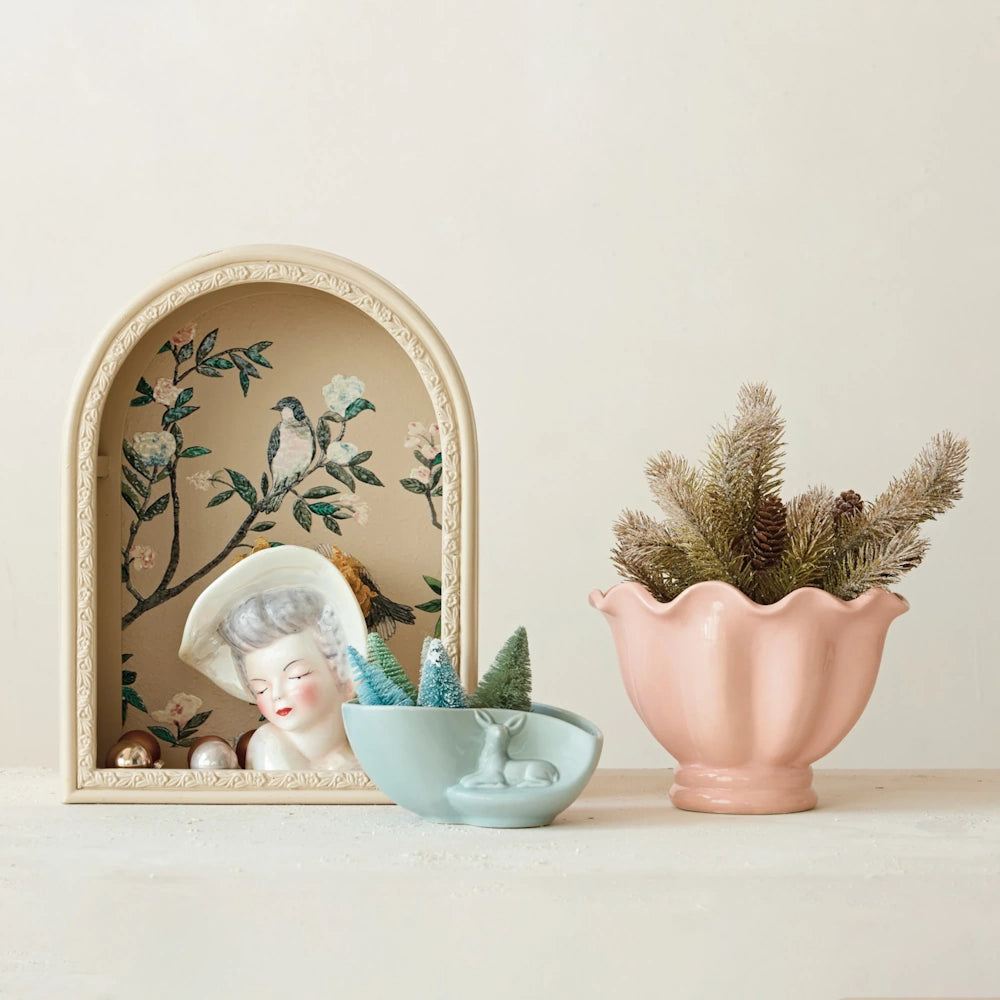 Styled view of a white ceramic vintage reproduction lady head vase displayed inside a decorative arch frame.