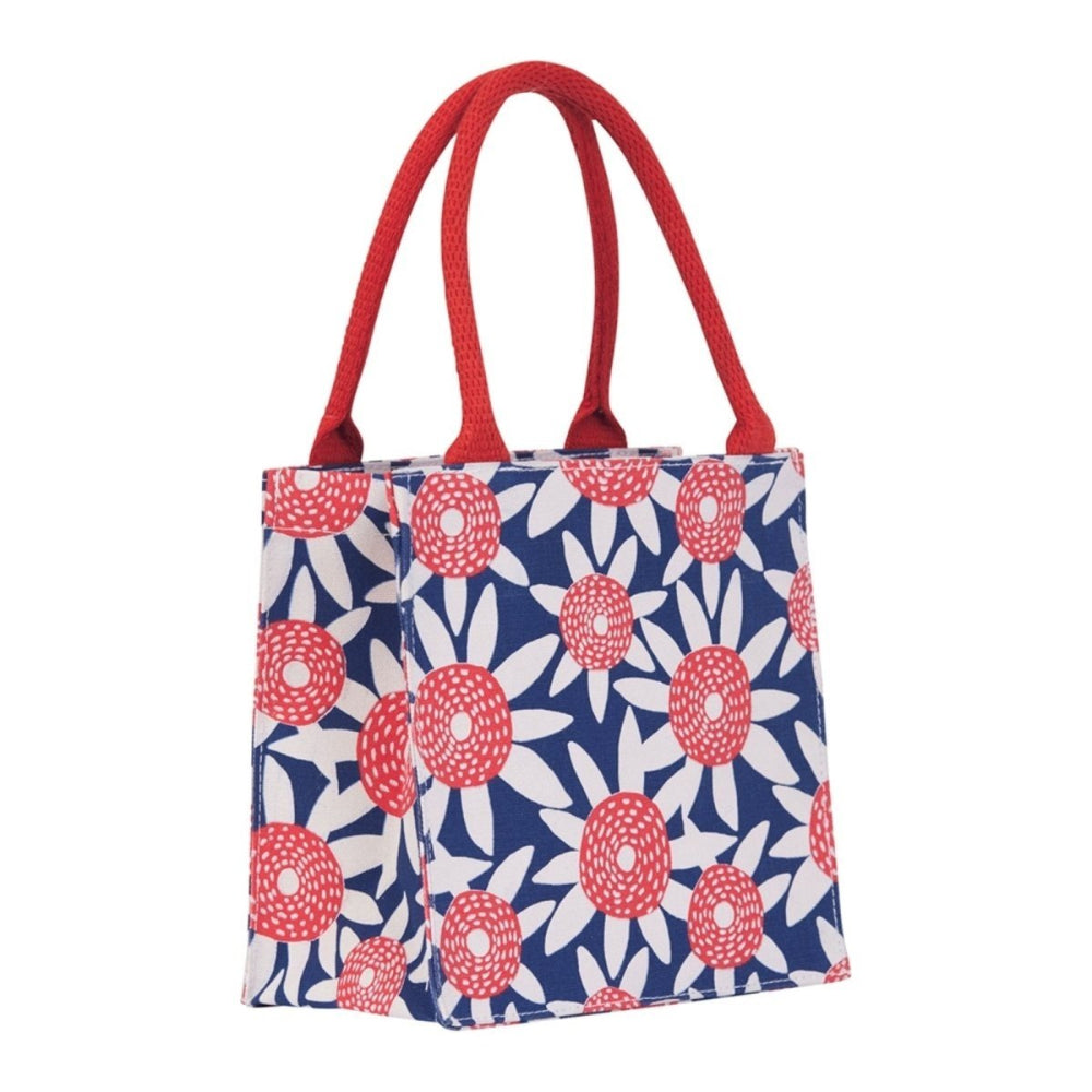 Blue canvas tote bag with a white and red floral pattern and bright red fabric handles.