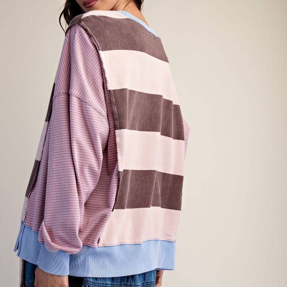Back view of a striped terry pullover featuring pink, brown, and light blue color-blocked patterns.