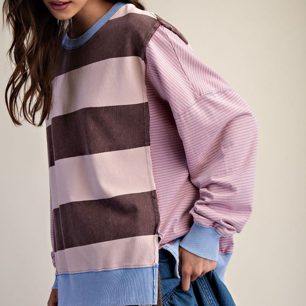 Casual side view of a brown and pink striped long-sleeve terry pullover with blue cuffs.