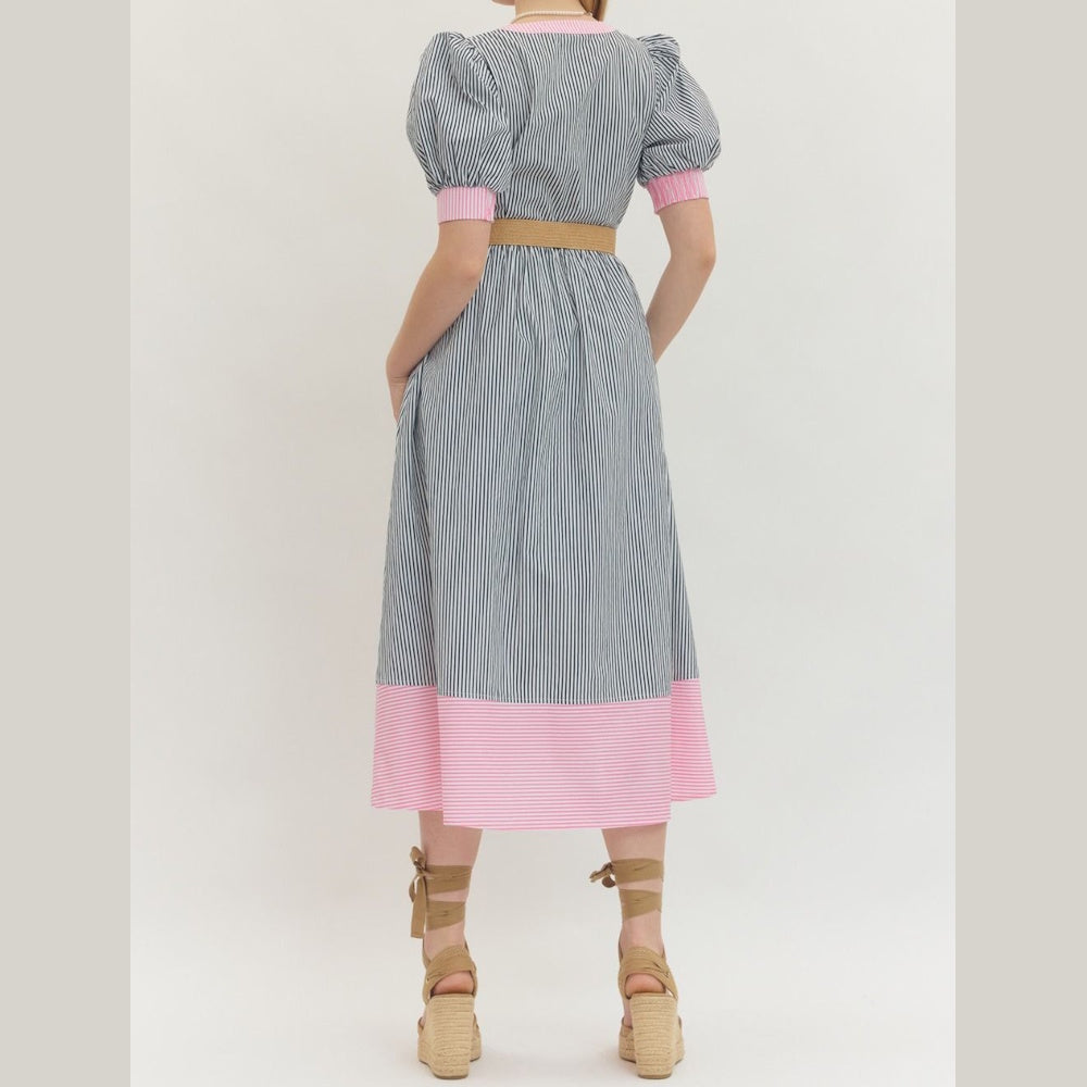 Back view of a striped midi dress with puff sleeves, pink trim, and a tan belt, styled with wedge lace-up sandals.