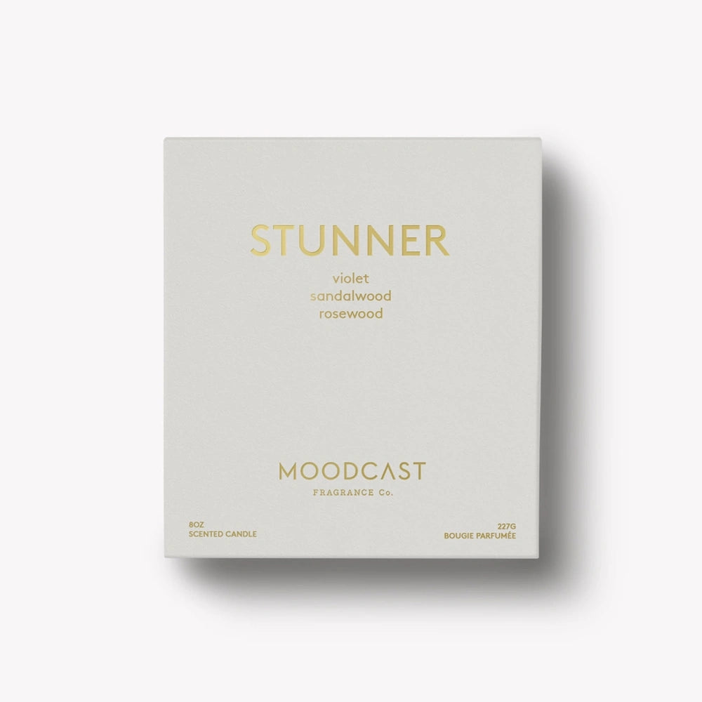 Light gray Moodcast "Stunner" scented candle packaging box with gold lettering on a white background.