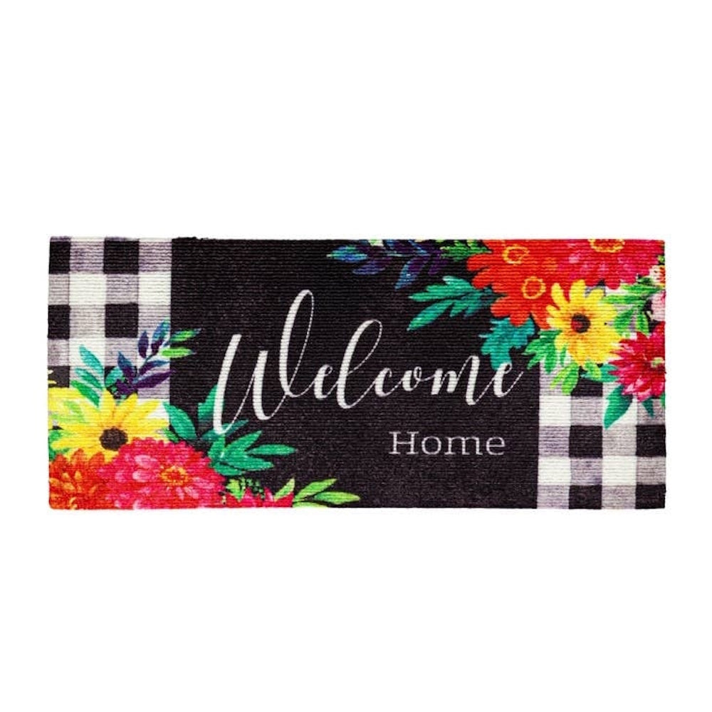 "Welcome Home" doormat with bright floral corners and a black and white plaid border.