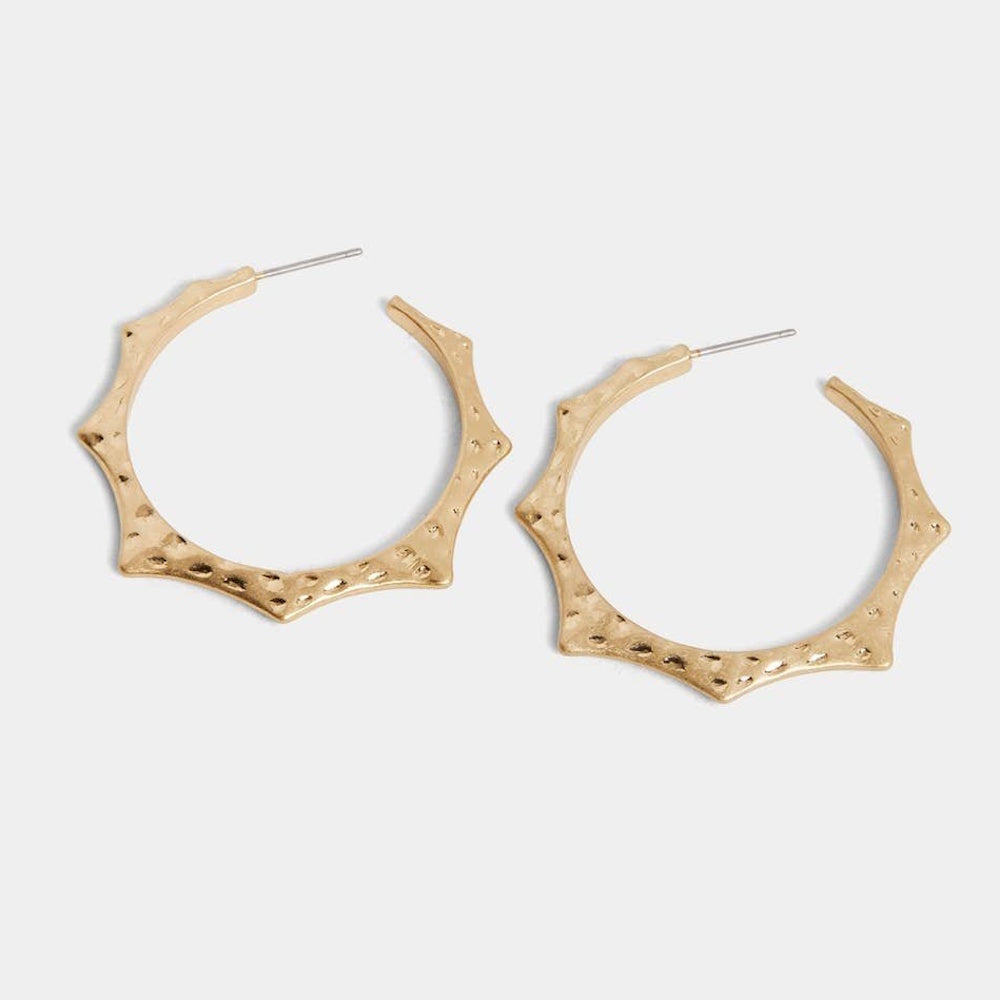 Gold hoop earrings with a textured, hammered finish and a pointed, sunburst-inspired outer edge.