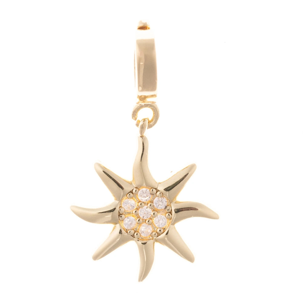 Gold sunburst charm with a pave crystal center on a plain white background.