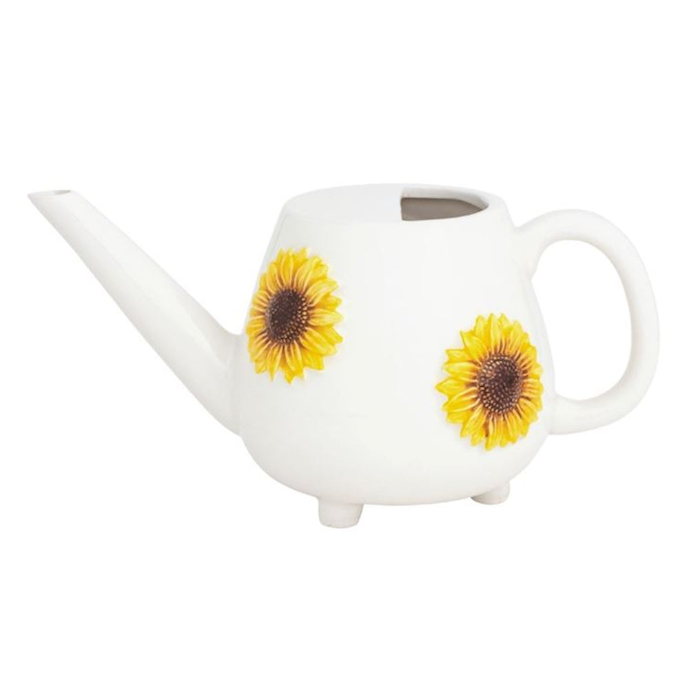 Small white ceramic watering can with yellow sunflower relief details, long spout, and rounded handle on a white background.