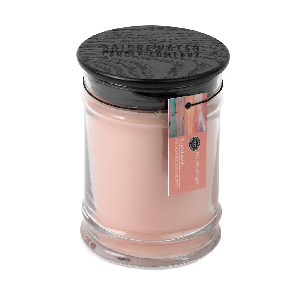 8.8 oz Sunkissed scented glass jar candle by Bridgewater Candle Company with a black wooden lid and peach-colored wax.