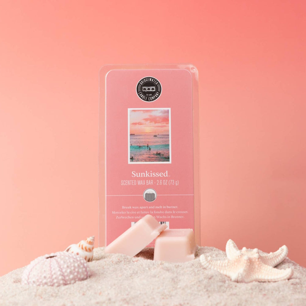 Pink Sunkissed scented wax melts and packaging on a beach sand display with a starfish.