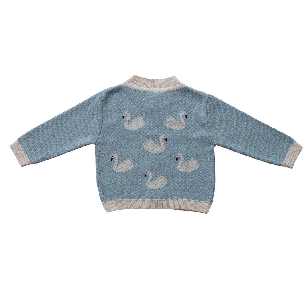 Back view of light blue cotton knit baby cardigan sweater featuring a white swan pattern and ribbed cream trim.