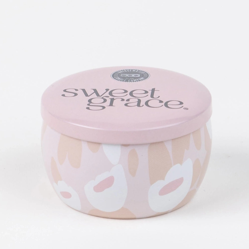 Round pink patterned candle tin labeled "sweet grace" on its lid against a plain white background.