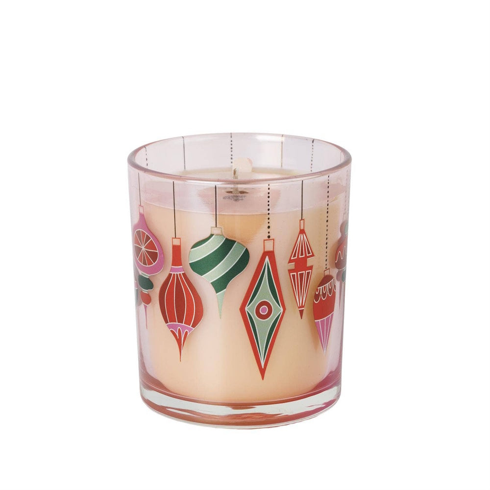 Sweet Grace soy candle in a clear glass vessel decorated with colorful hanging Christmas ornaments.