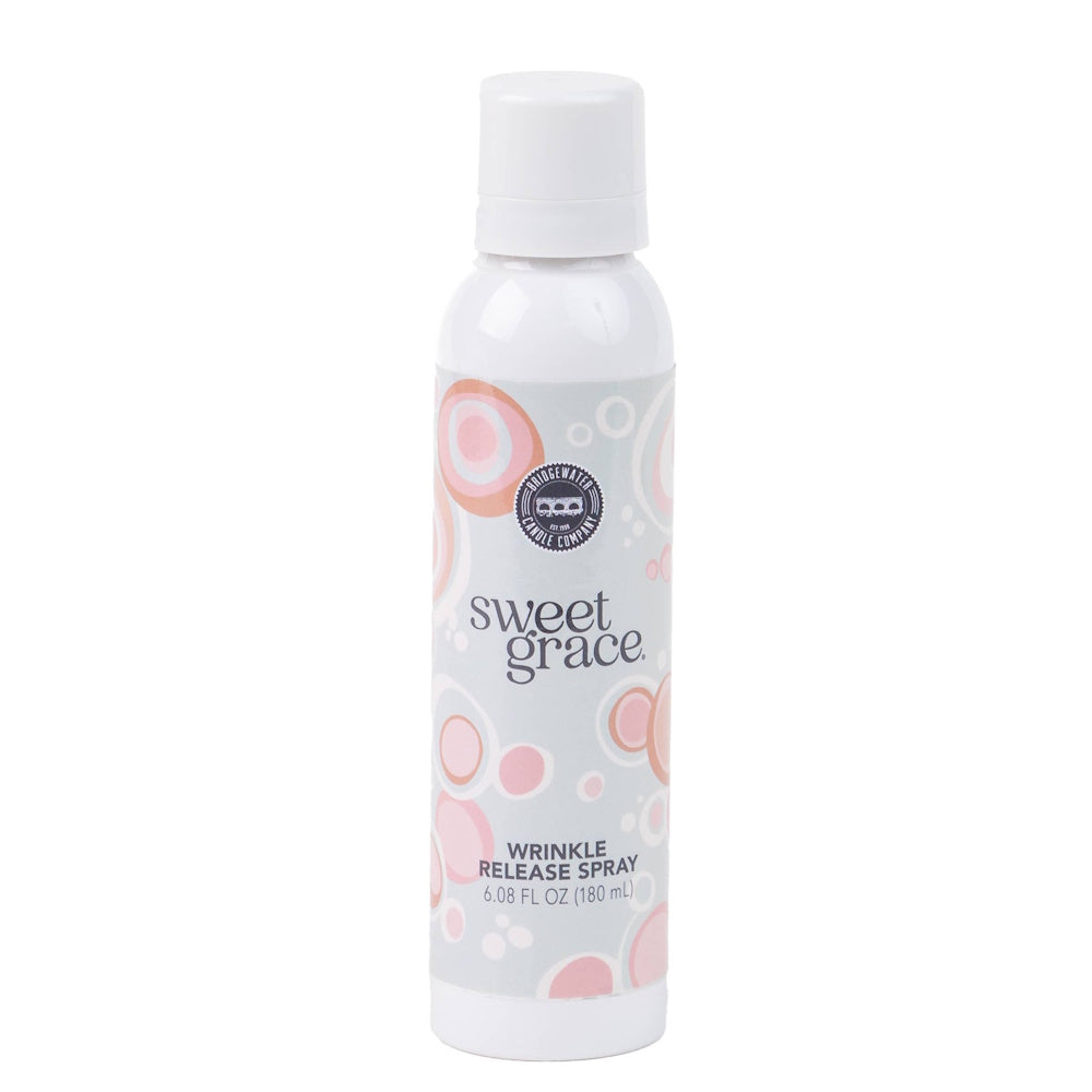 White spray bottle of Sweet Grace wrinkle release spray with pink patterned label on white backdrop.