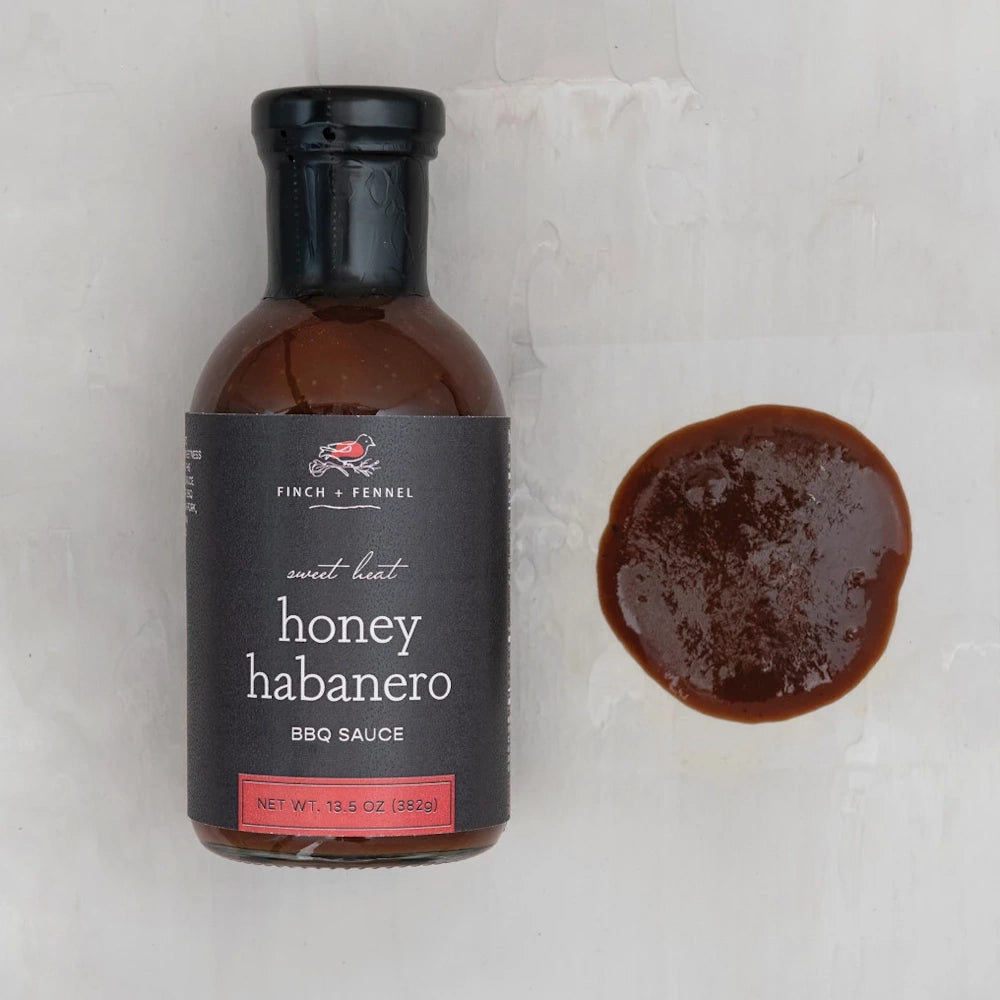 Finch + Fennel Honey Habanero BBQ Sauce bottle and a sauce dollop on a white background.