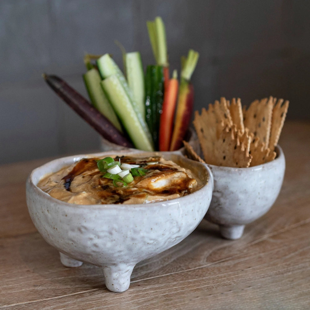 Creamy bourbon dip topped with green onions, served in stone bowls with fresh cucumber, carrots, and seeded crackers.
