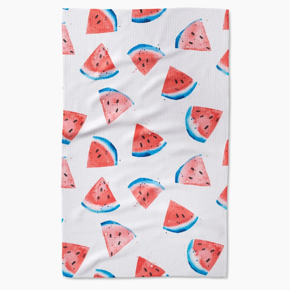 White tea towel with a repeating watercolor pattern of red and blue watermelon slices.