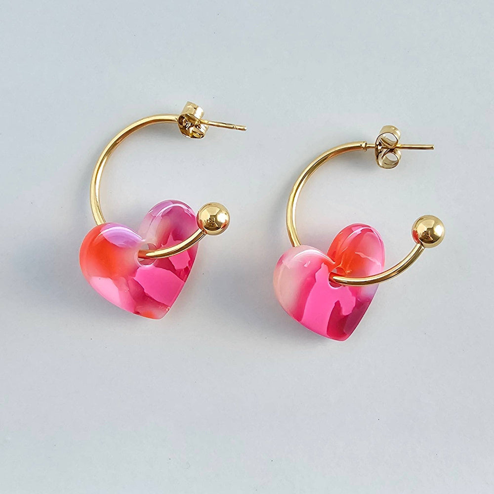 Sweetheart Hoops in Tickled Pink with marbled resin heart charms on gold-plated hoops.