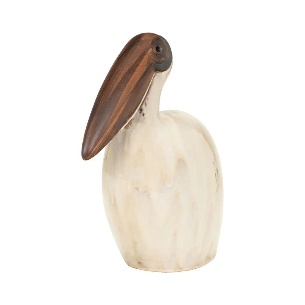 Three-quarter view of a tall ceramic pelican figurine in off-white with a smooth brown beak.