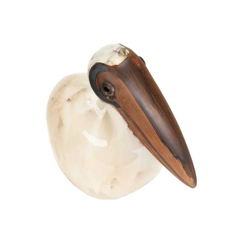 Top-down view of a ceramic pelican figurine showing its smooth beige body and prominent brown beak.
