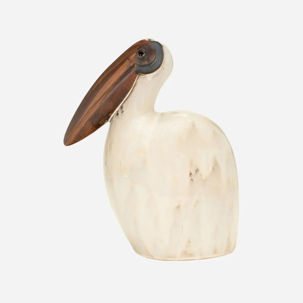 Side profile of a tall ceramic pelican figurine in marbleized off-white with a large brown beak.