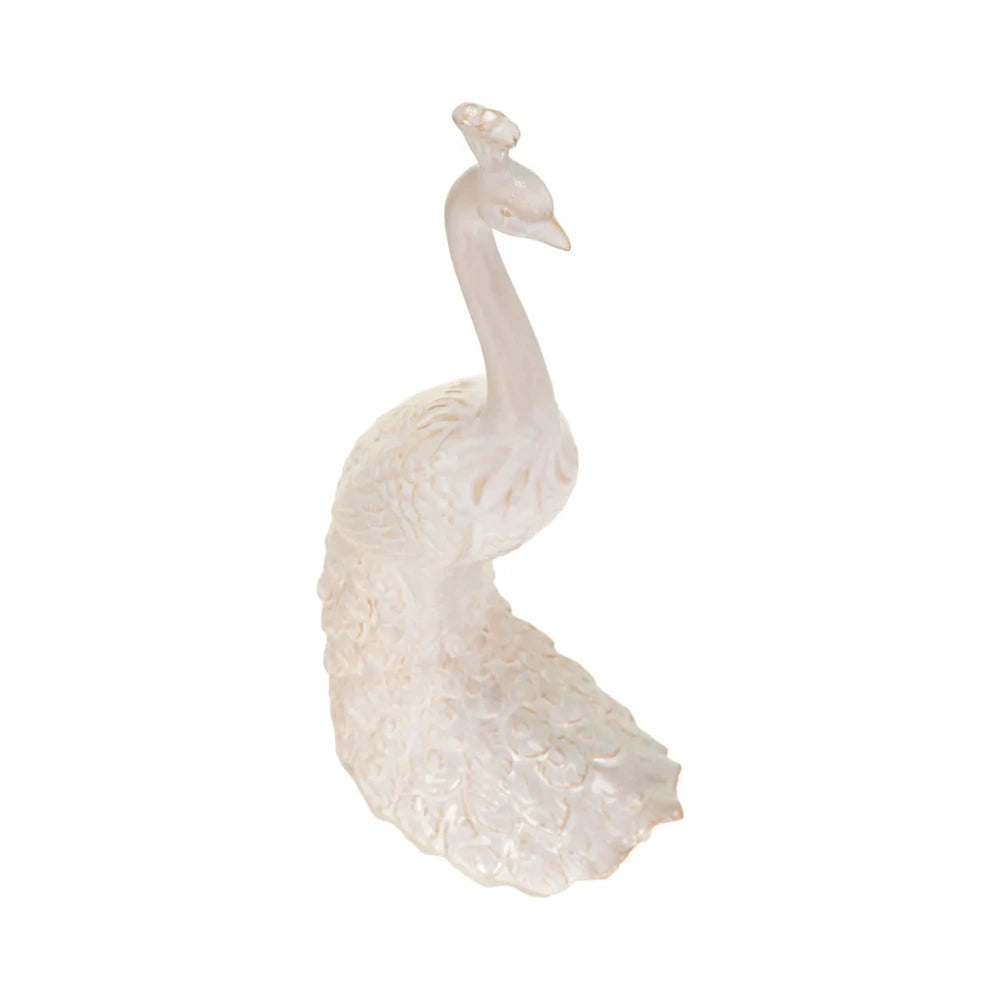 Three-quarter view of an upright cream-colored peacock sculpture showing detailed feather patterns on its tail.