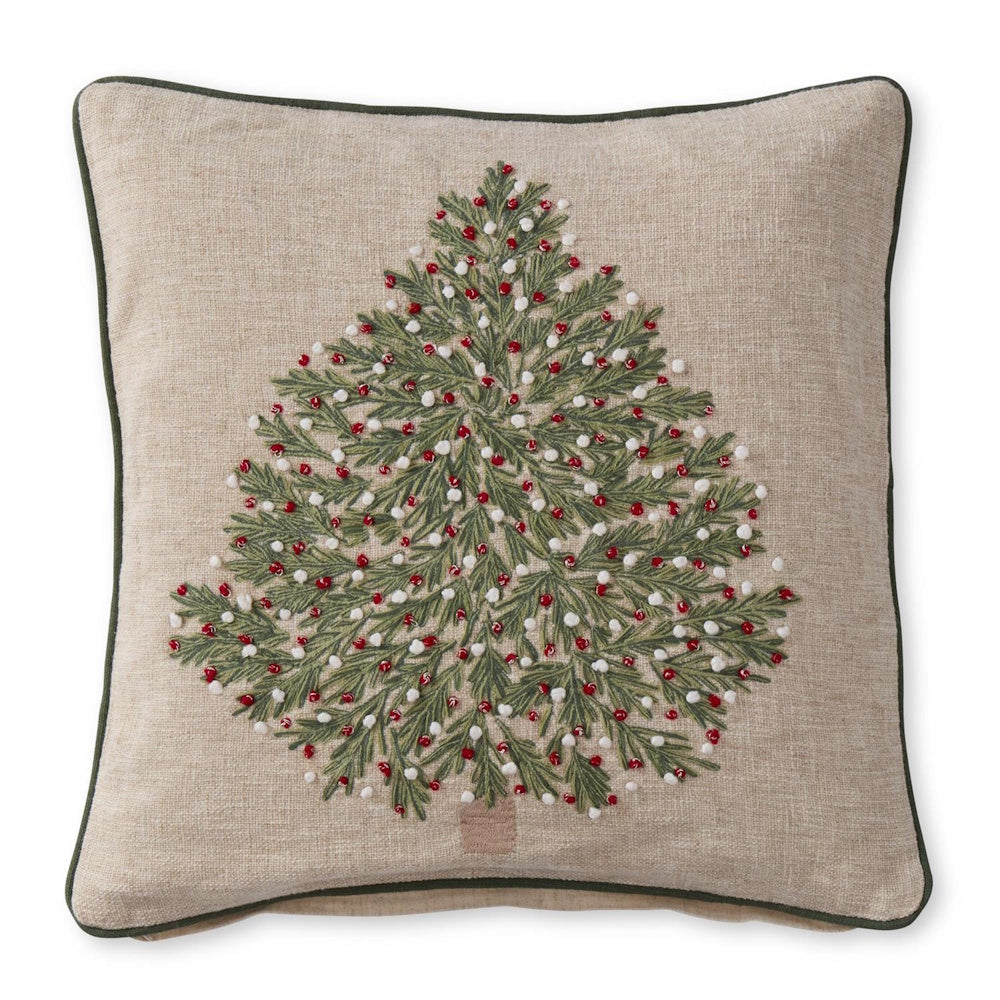 A tan Christmas tree embroidered pillow featuring a detailed green tree with red and white French knots.