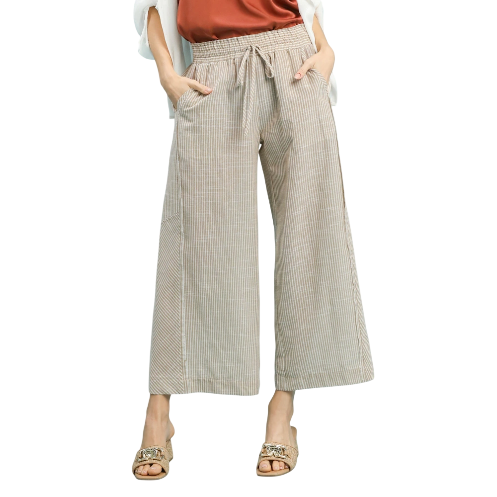 Tan striped wide-leg linen pants featuring a drawstring waist and side pockets, styled with sandals.